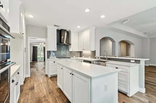 a kitchen with white cabinets appliances and a fireplace