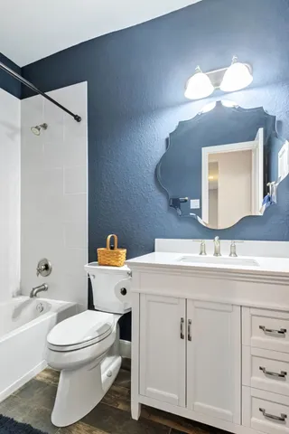 a bathroom with a toilet a sink a tub and mirror