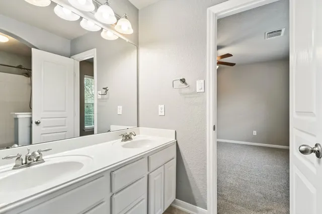 a bathroom with a double vanity sink and a mirror