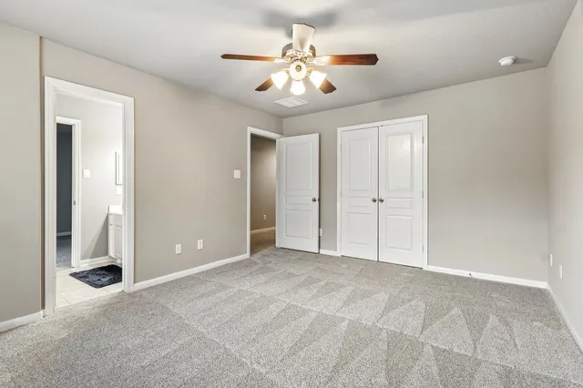 a view of an empty room with a chandelier fan