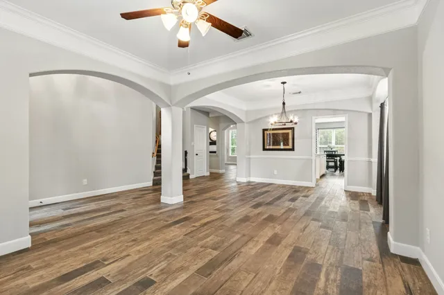 a view of a hallway with wooden floor and a chandelier