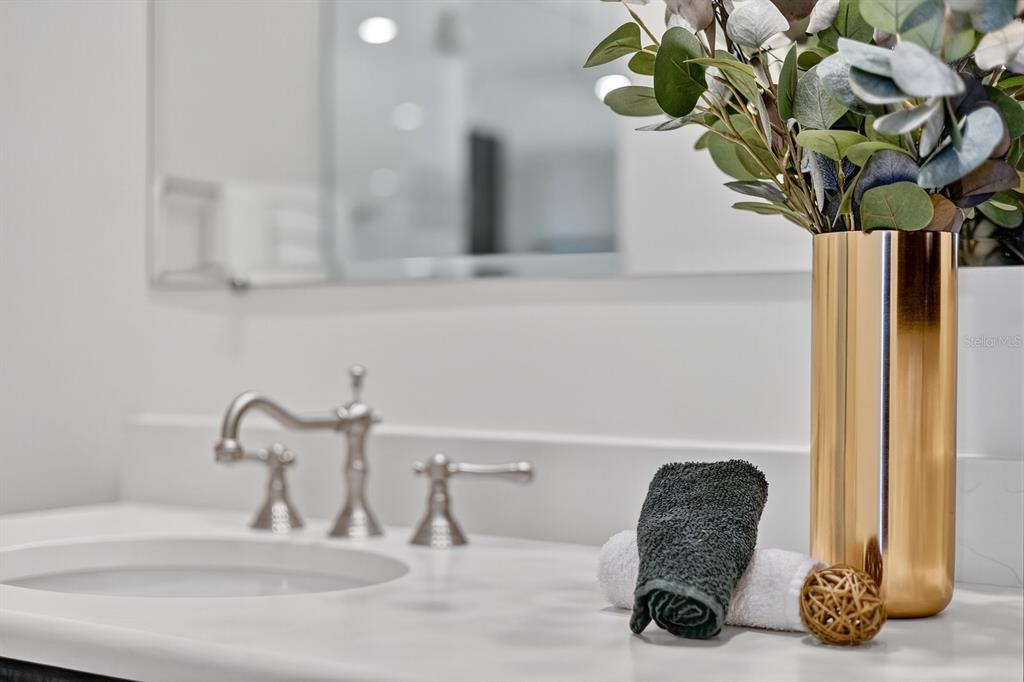 415 L L Ambiance Drive, Unit C403 Longboat Key, FL 34228 - Photo 34 of 81 a vase of flowers sitting on a bathroom sink