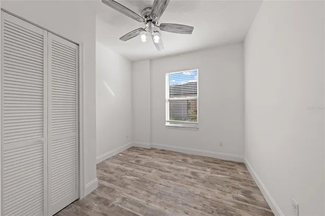 an empty room with windows and fan