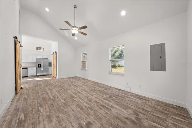 a view of empty room with wooden floor and ceiling fan