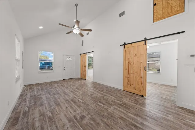 a view of a livingroom with wooden floor and a ceiling fan
