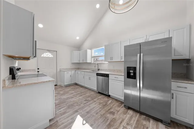 a kitchen with a refrigerator a sink and a stove top oven