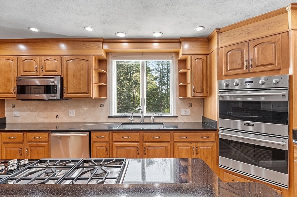 83 Weldon Farm Road Rowley, MA 01969 - Photo 9 of 41 a kitchen with stainless steel appliances granite countertop a stove a sink and a microwave