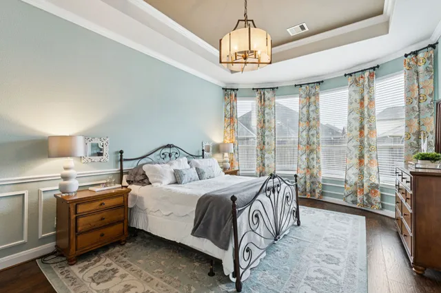 a bedroom with a bed and a chandelier