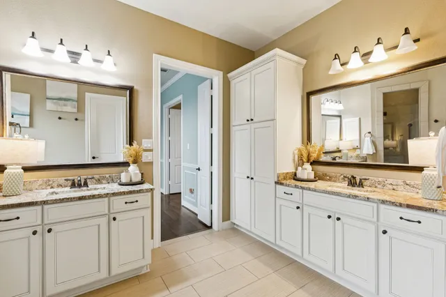 a spacious bathroom with a granite countertop sink and a mirror