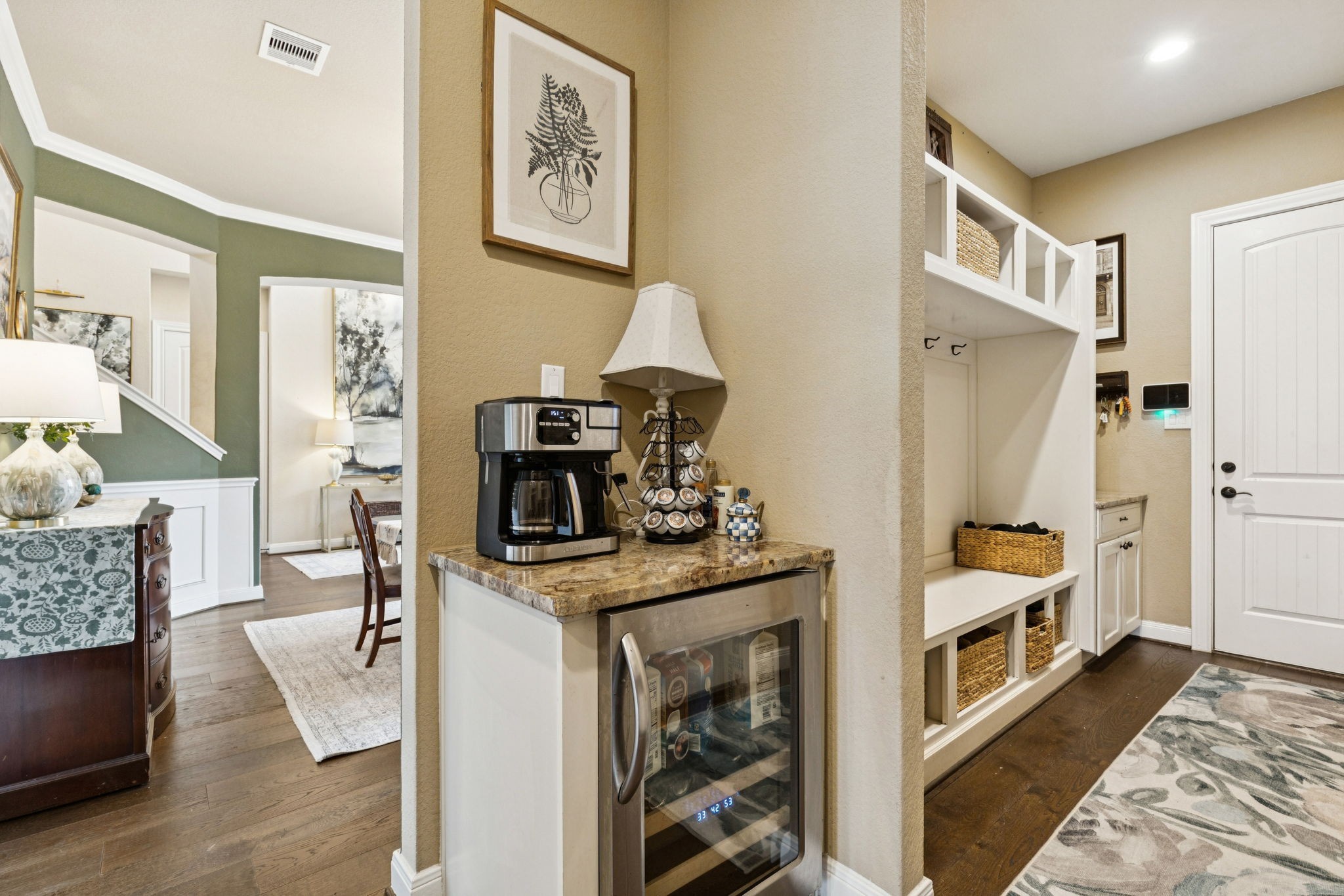 1118 Fragile Sail Court Katy, TX 77494 - Photo 10 of 35 Enjoy the convenience of a stylish beverage station featuring a built-in wine fridge and granite countertop, seamlessly tucked beside custom mudroom-style built-ins with bench seating and storage—perfect for daily organization and effortless entertaining.