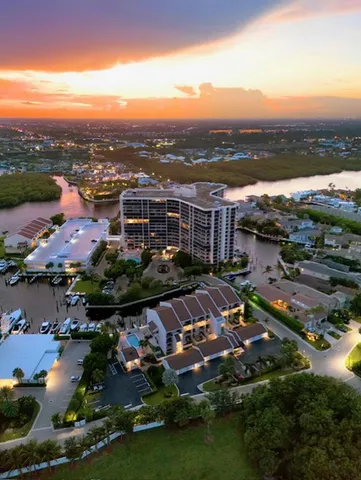 an aerial view of a city with lots of residential buildings ocean and mountain view in back