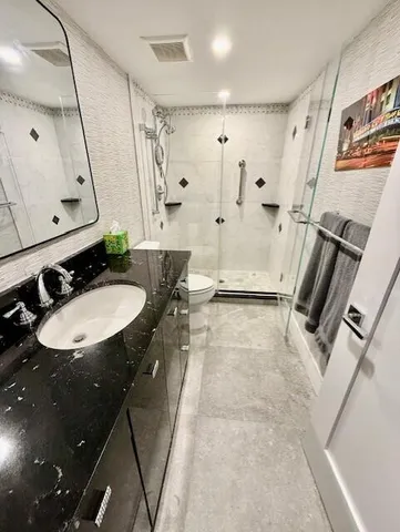 a bathroom with a sink a toilet and shower