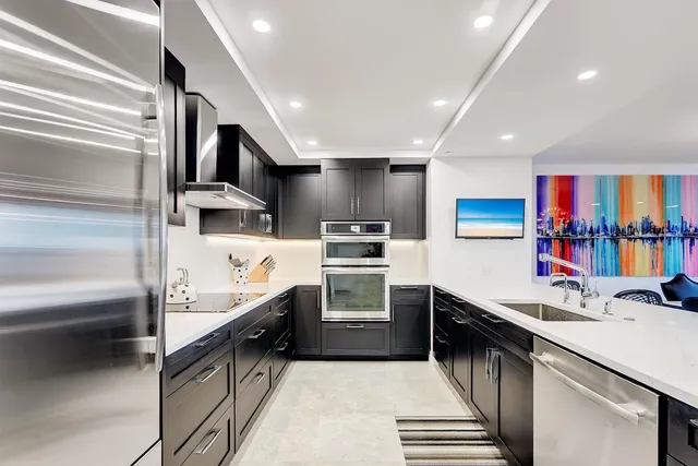 a kitchen with stainless steel appliances a sink and a refrigerator