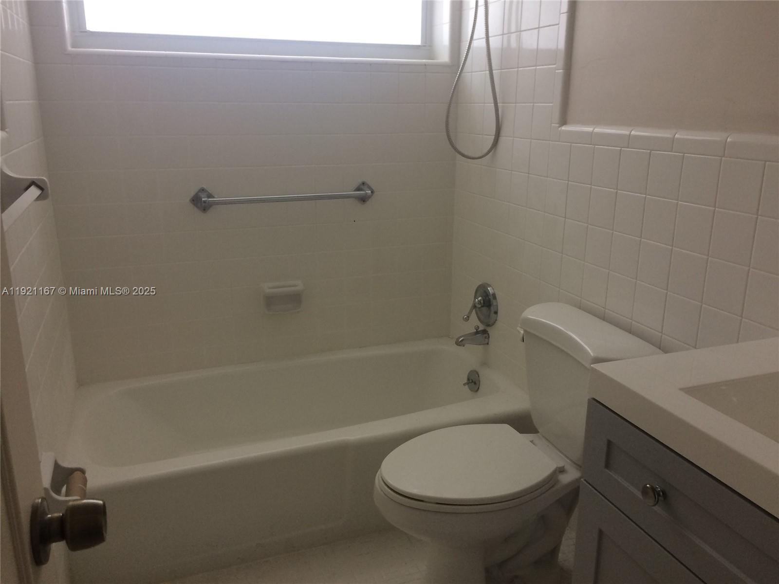 255 Sunrise Drive, Unit 103 Key Biscayne, FL 33149 - Photo 6 of 11 a bathroom with a toilet and a bath tub