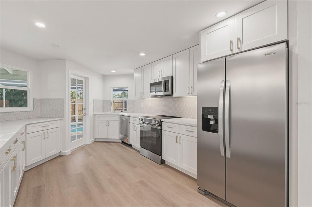 1330 Horizon Road Venice, FL 34293 - Photo 10 of 40 a kitchen with granite countertop a refrigerator sink and cabinets