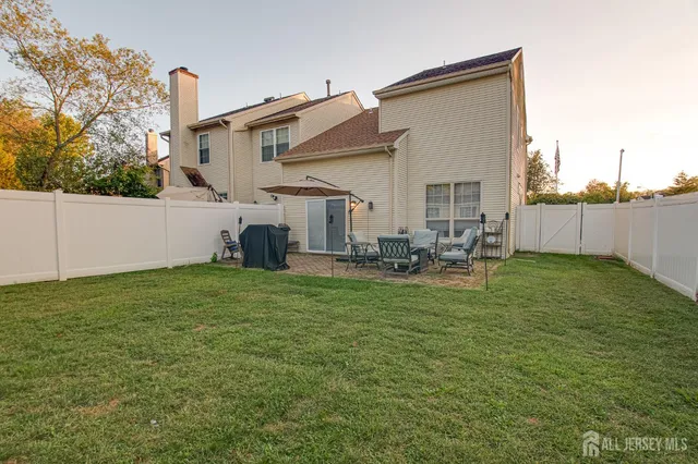 a backyard of a house with table and chairs