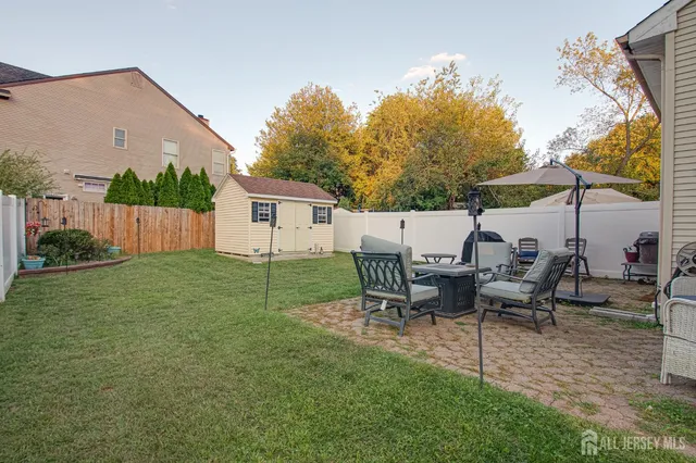 a view of a backyard with table and chairs potted plants and a palm tree