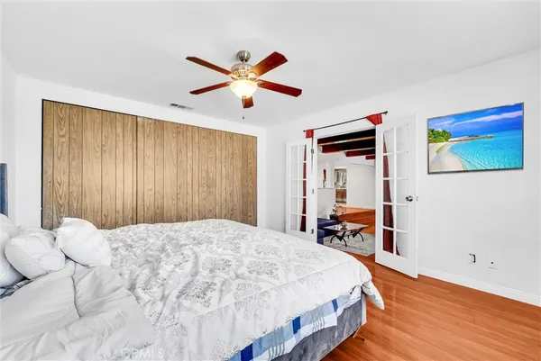a bedroom with a bed and wooden floor
