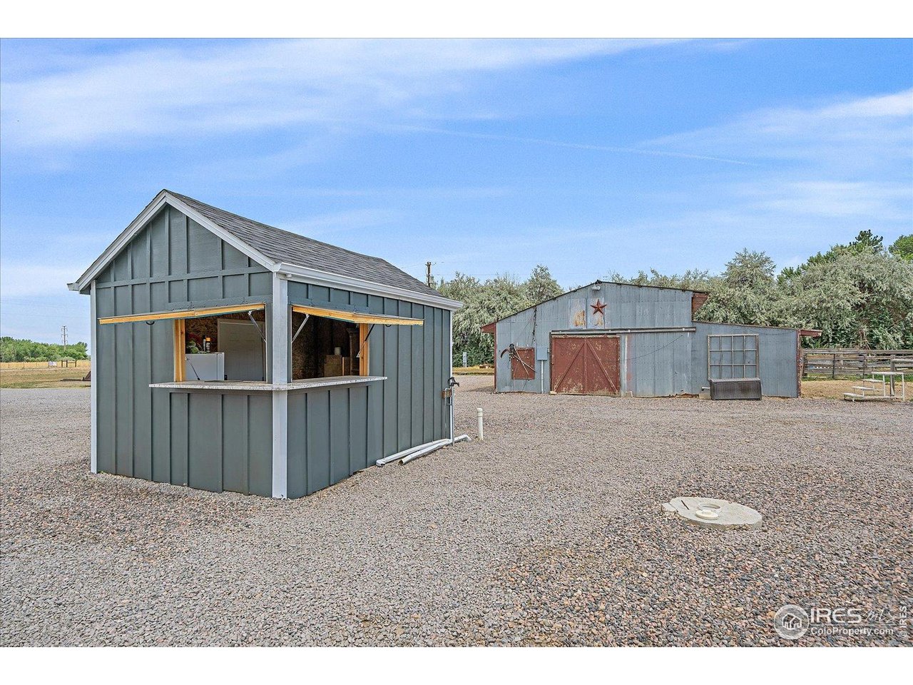 11724 Kenosha Road Longmont, CO 80504 - Photo 36 of 49 Well house/Shed/Bar with windows open and barn behind