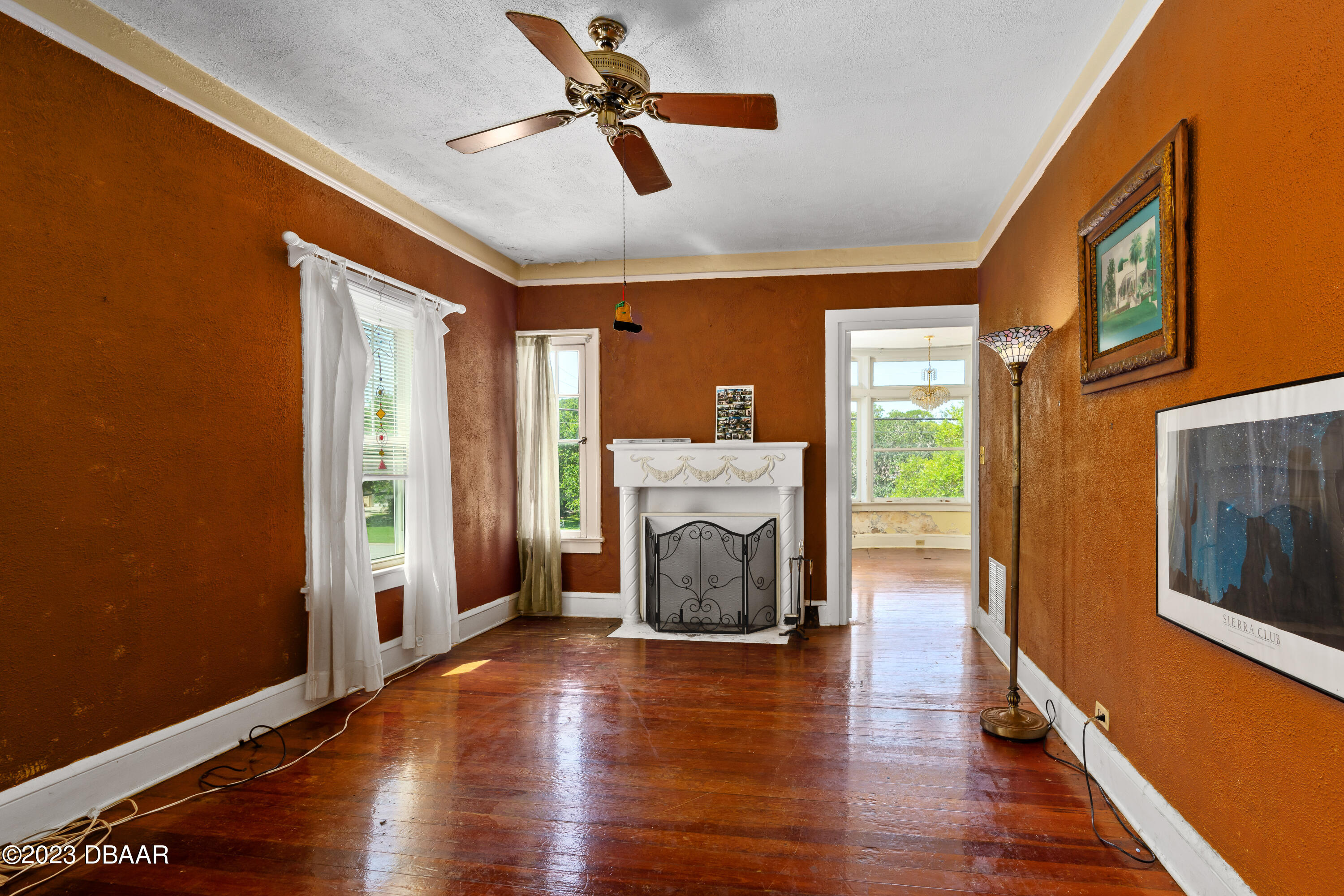 75 Seminole Avenue Ormond Beach, FL 32176 - Photo 17 of 59 a view of a livingroom with wooden floor a ceiling fan and a fireplace