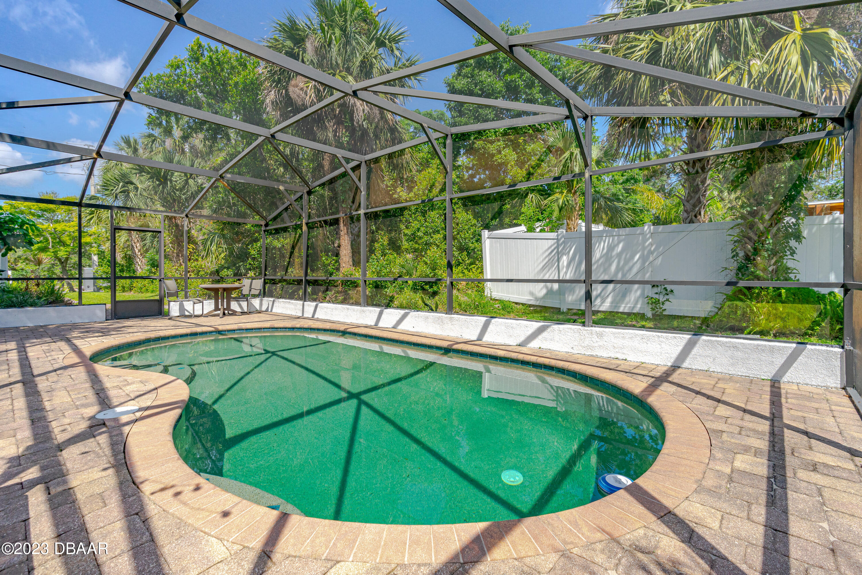 75 Seminole Avenue Ormond Beach, FL 32176 - Photo 10 of 59 a view of a swimming pool with a patio and yard of the house