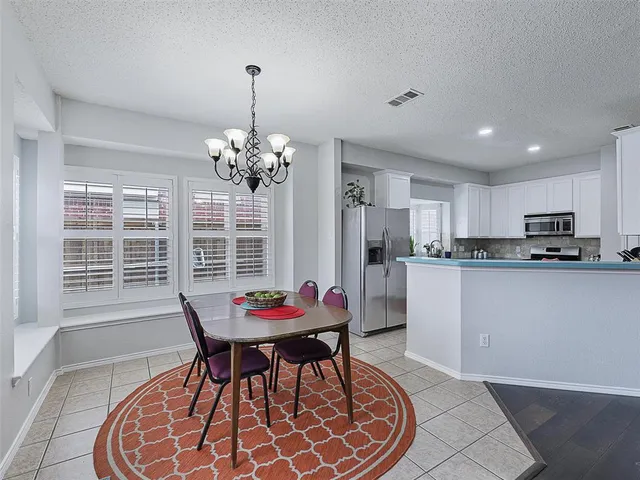a kitchen with a refrigerator and a table
