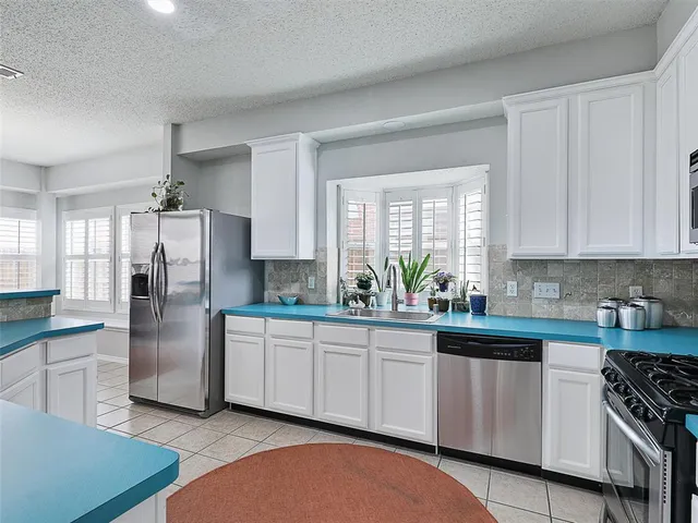 a kitchen with stainless steel appliances granite countertop a stove a sink dishwasher and a refrigerator