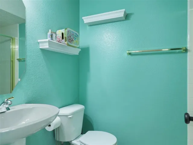 a white toilet sitting next to a bathroom sink