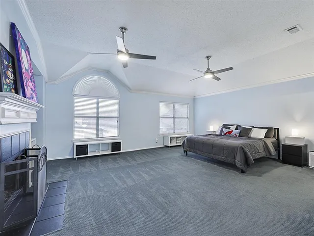 a spacious bedroom with a bed and a chandelier