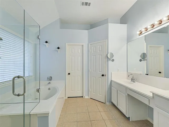 a bathroom with a tub sink and mirror