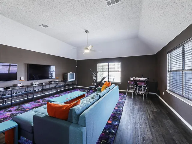 a living room with furniture a flat screen tv and a large window