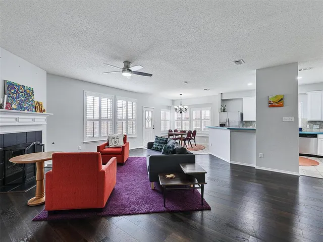 a living room with fireplace furniture and a large window