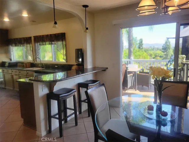 a room with stainless steel appliances granite countertop table chairs and a large window