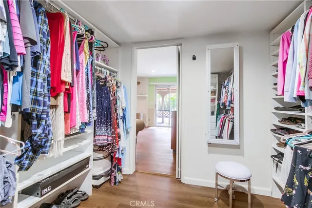 a view of walk in closet with clothes and shoes