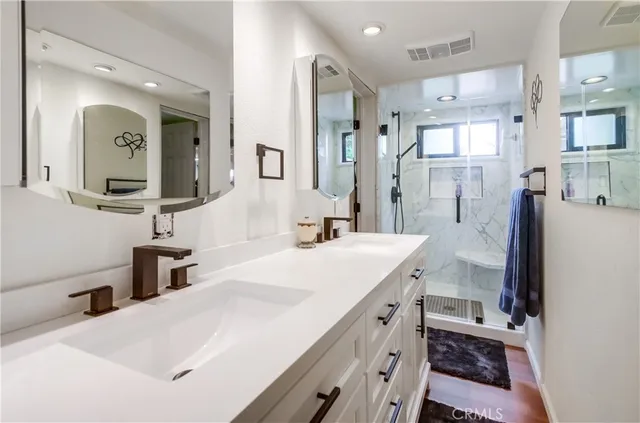 a bathroom with a double vanity sink mirror and shower