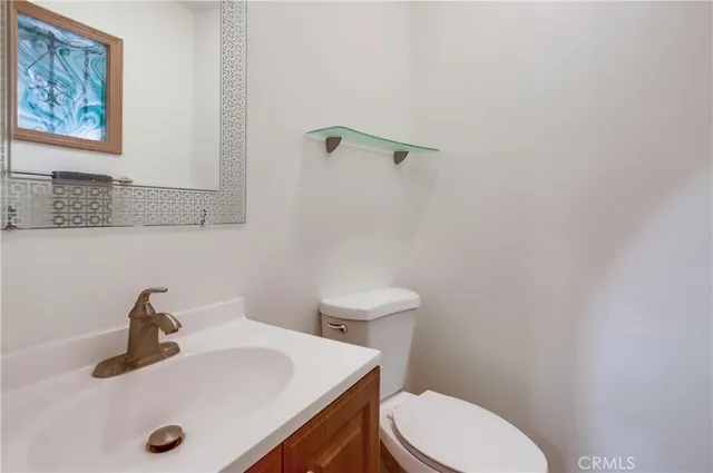 a bathroom with a sink a toilet and mirror