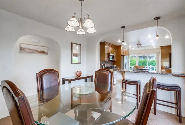 a dining room with wooden floor a chandelier a wooden table and chairs