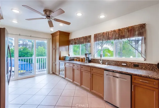 a large kitchen with kitchen island granite countertop a large window cabinets and stainless steel appliances