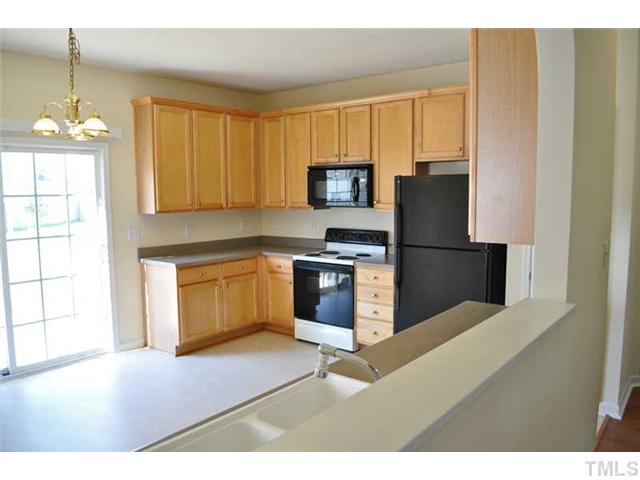 8501 Neuse Hunter Drive Raleigh, NC 27616 - Photo 6 of 16 a kitchen with stainless steel appliances granite countertop a stove a sink and a refrigerator with wooden floor