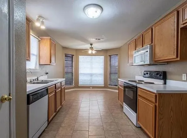 a kitchen with a stove sink and cabinets