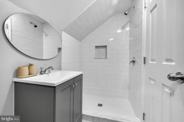 a bathroom with a sink a mirror and a shower