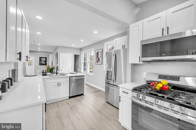 a kitchen with stainless steel appliances a stove refrigerator sink and microwave