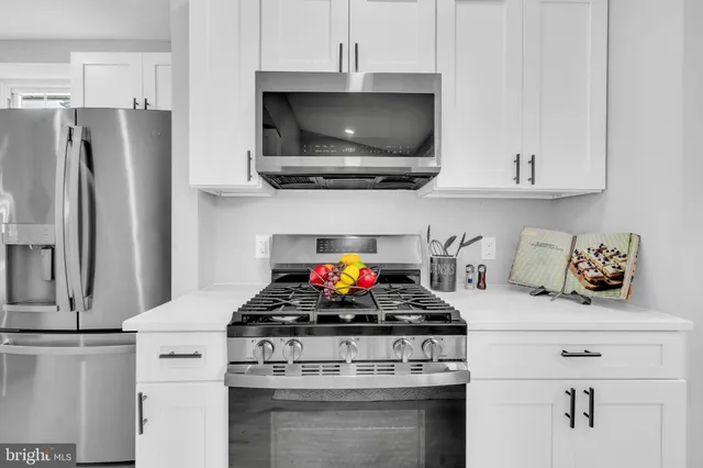 a kitchen with stainless steel appliances a stove a microwave and cabinets