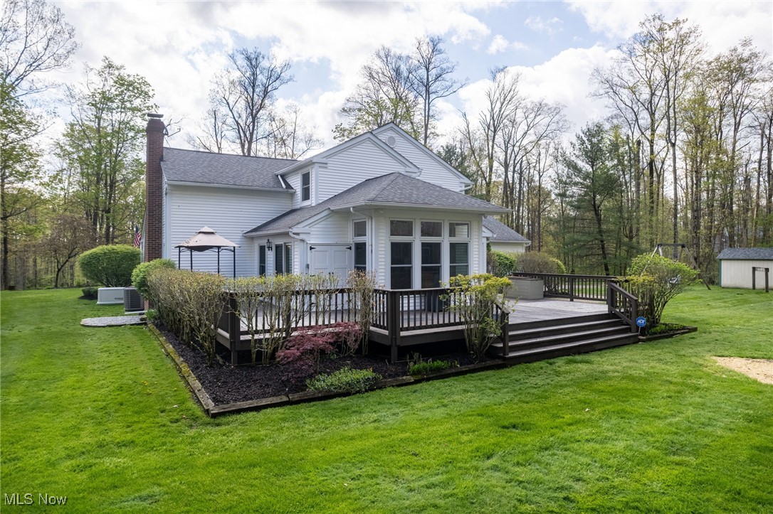 14566 West Ridge Road Novelty, OH 44072 - Photo 4 of 49 Rear view of house with a yard, an outdoor structure, a chimney, and a deck