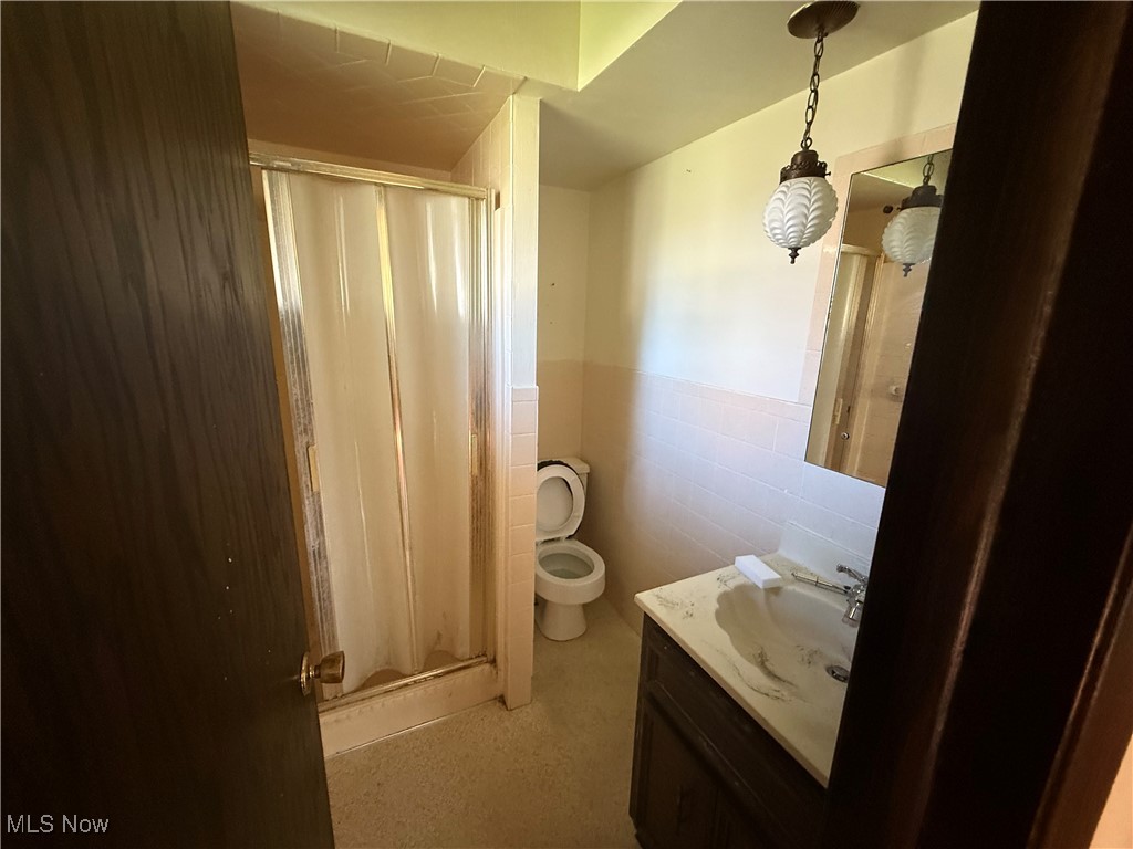 683 Robinson Road Campbell, OH 44405 - Photo 15 of 23 Bathroom with a shower stall, vanity, tile walls, and wainscoting