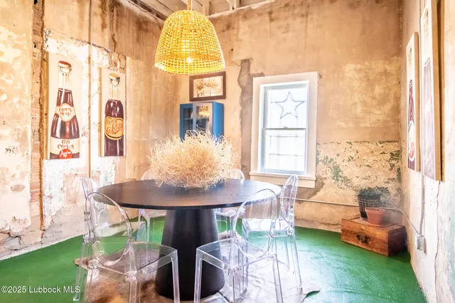 a living room with furniture and paintings on the wall