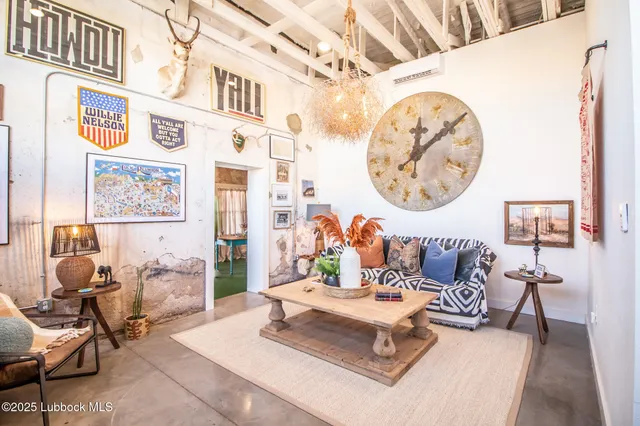 a living room with furniture a table and a wall painting