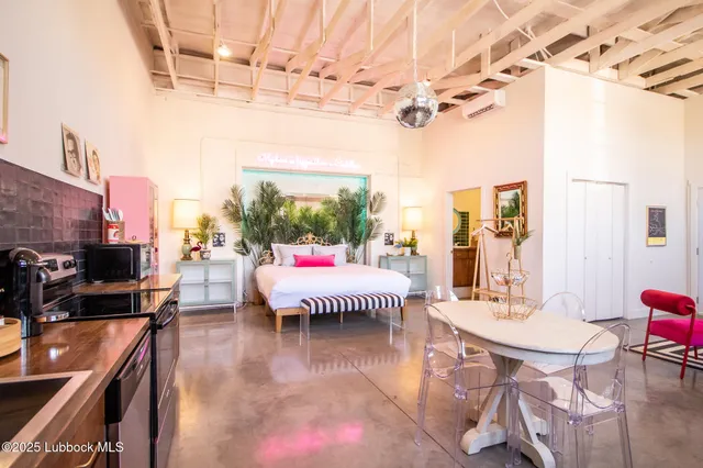 a living room with a couch and a dining table with wooden floor