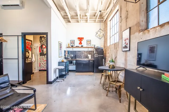 a living room with furniture a flat screen tv and gym equipment