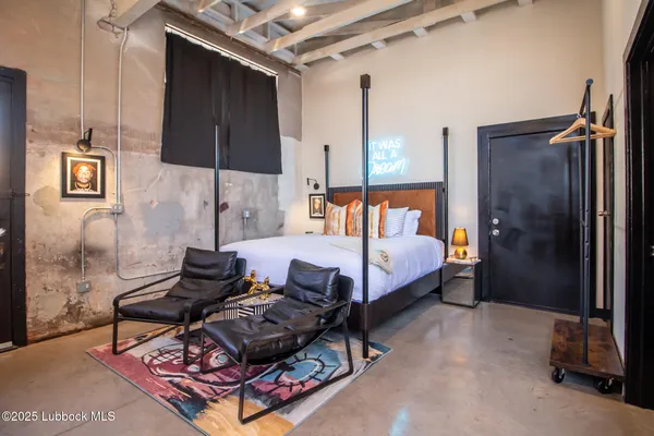 a bedroom with a bed and a painting on the wall